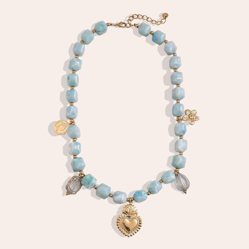 Collier Perles Cubiques Bleu Ciel & Charms – fond beige